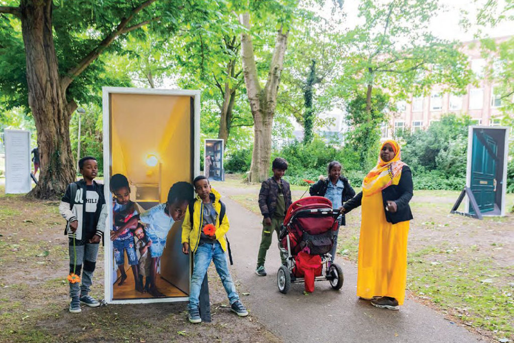 Moeder en kinderen bij kunstproject in het park