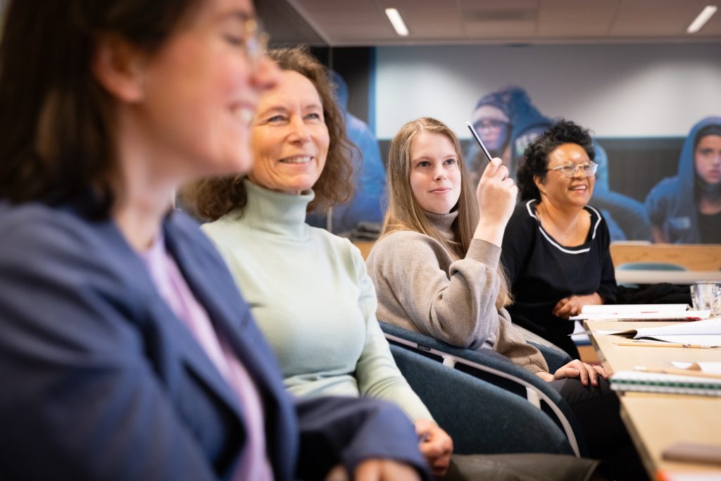 Vier cursisten van de LKCAcademie kijken naar de trainer tijdens een training.